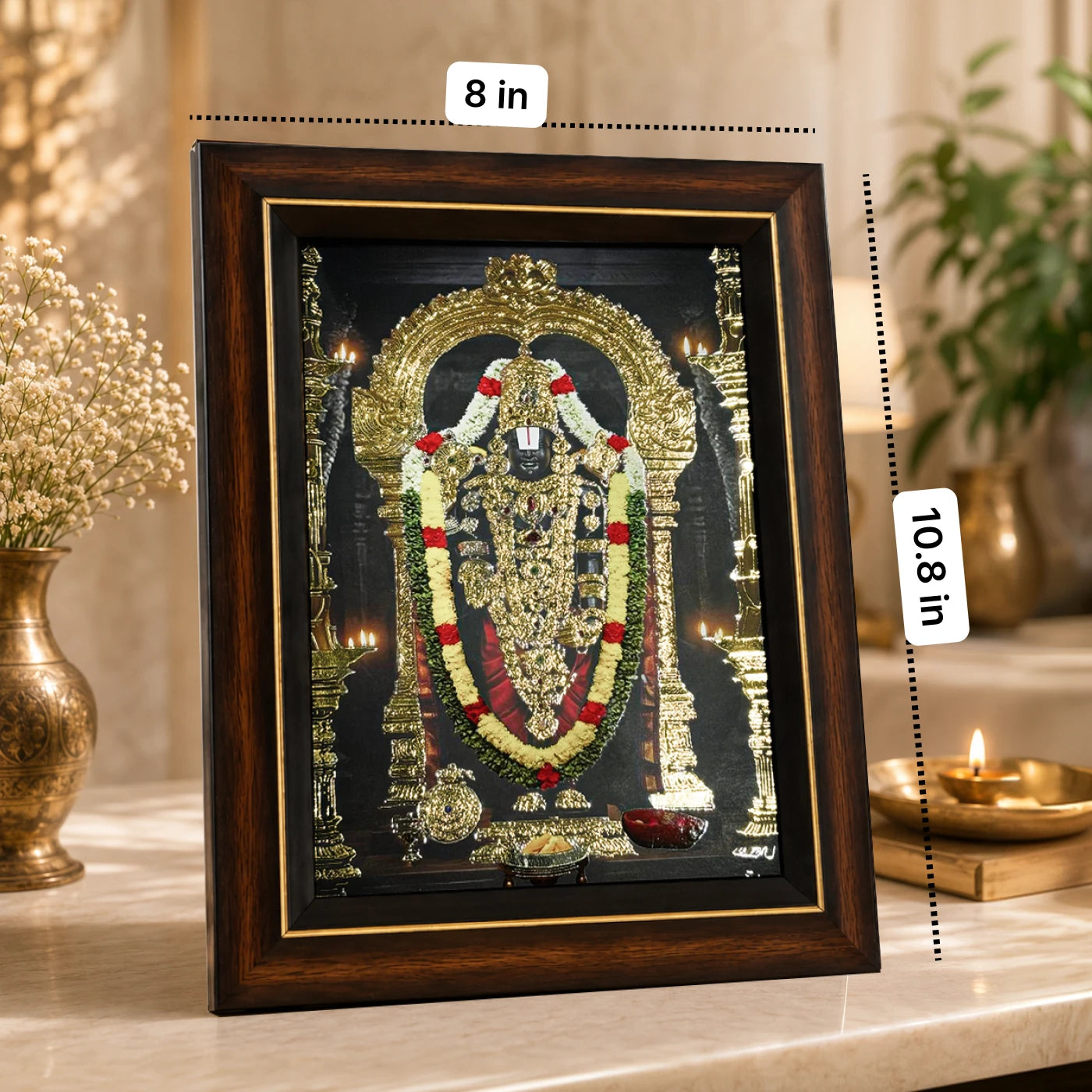 Golden-foiled ornaments of Lord Venkateswara on the Tirupati Balaji table frame